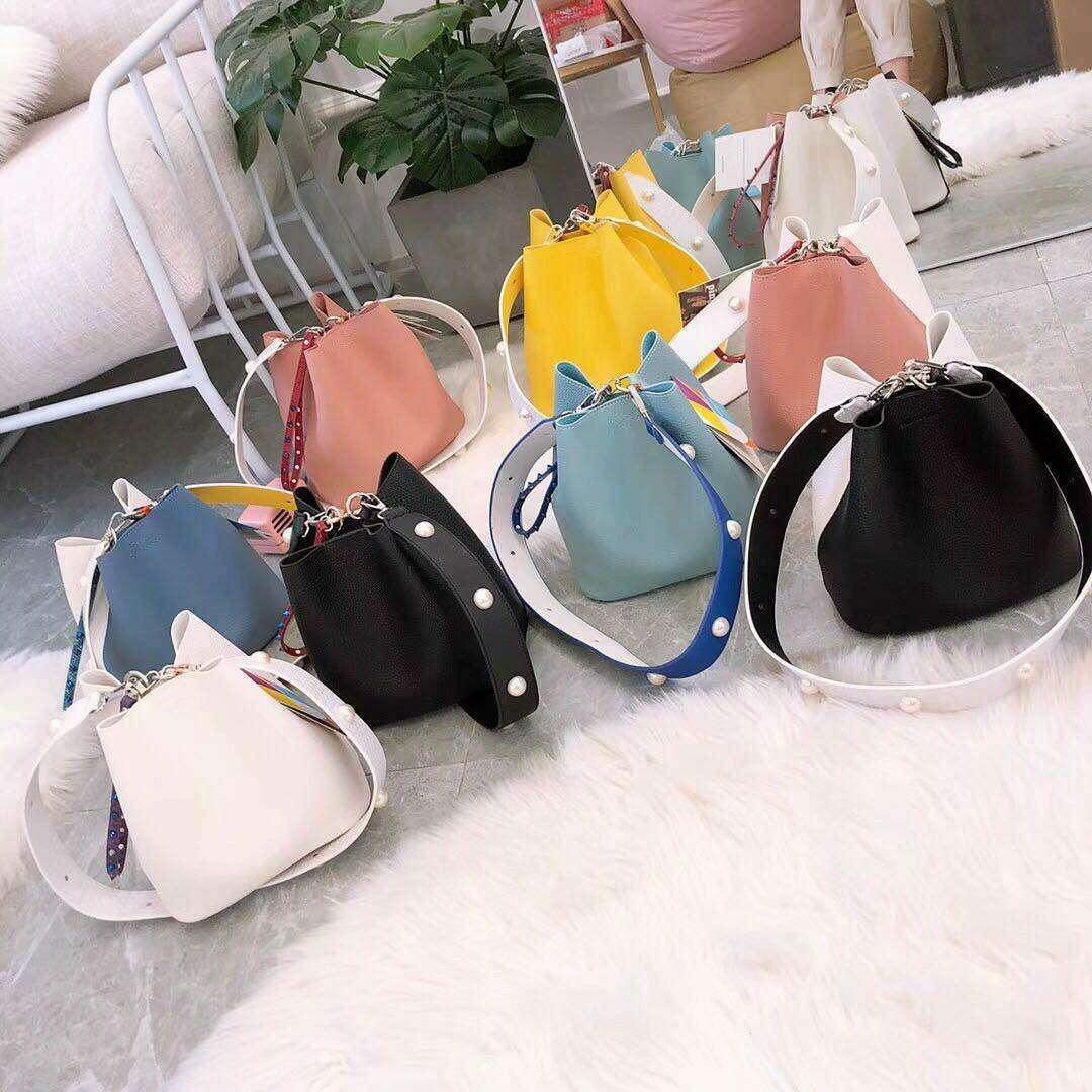 Small bucket bag with a uniquely designed shoulder strap