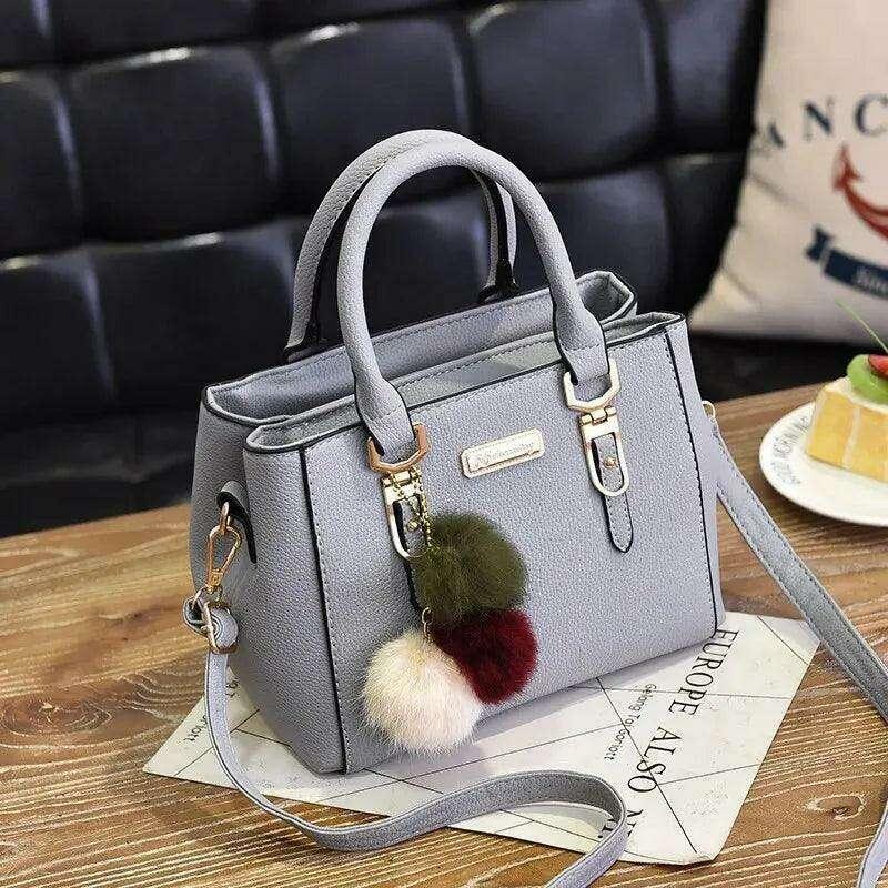 A fashionable handbag for women in a luxurious design with pom-pom accessories