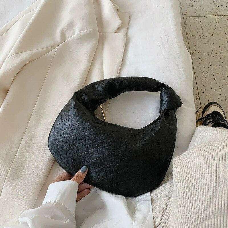 A fashionable bag in a round design with a delicate quilted texture.