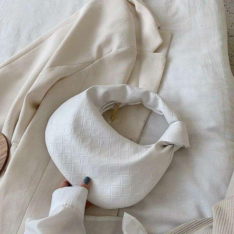 A fashionable bag in a round design with a delicate quilted texture.