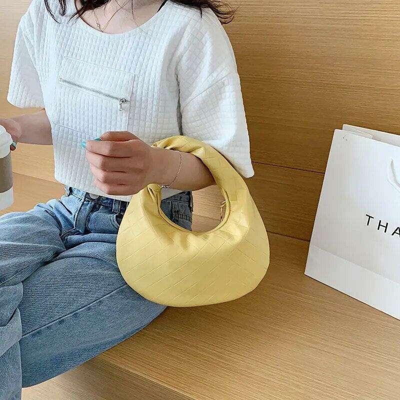 A fashionable bag in a round design with a delicate quilted texture.